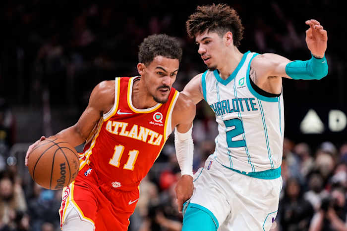 Hawks guard Trae Young dribbles the ball against Hornets guard LaMelo Ball.